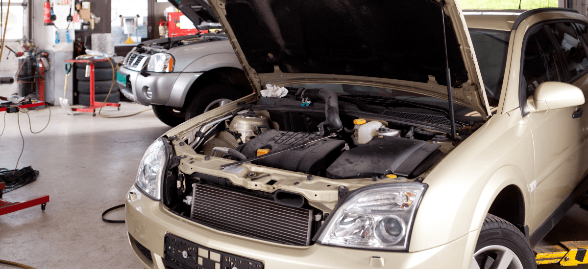 A car repair shop with two vehicles being serviced.